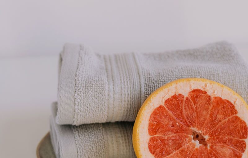 Handtücher und Grapefruit als ruhiges Wellnessmotiv