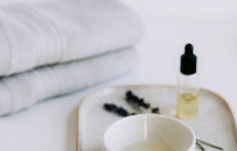 Massageöl und Handtücher als Wellnessmotiv